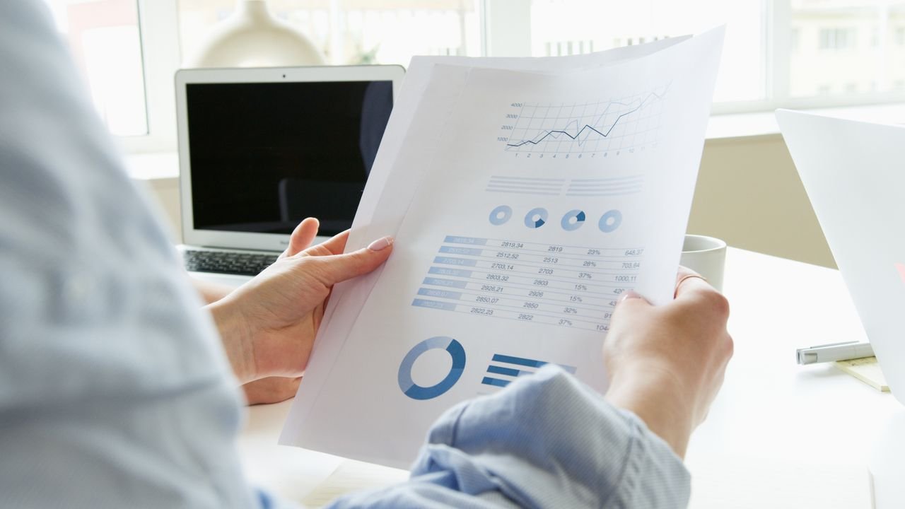 about-us-02 Close-up of a person analyzing business charts and graphs indoors.